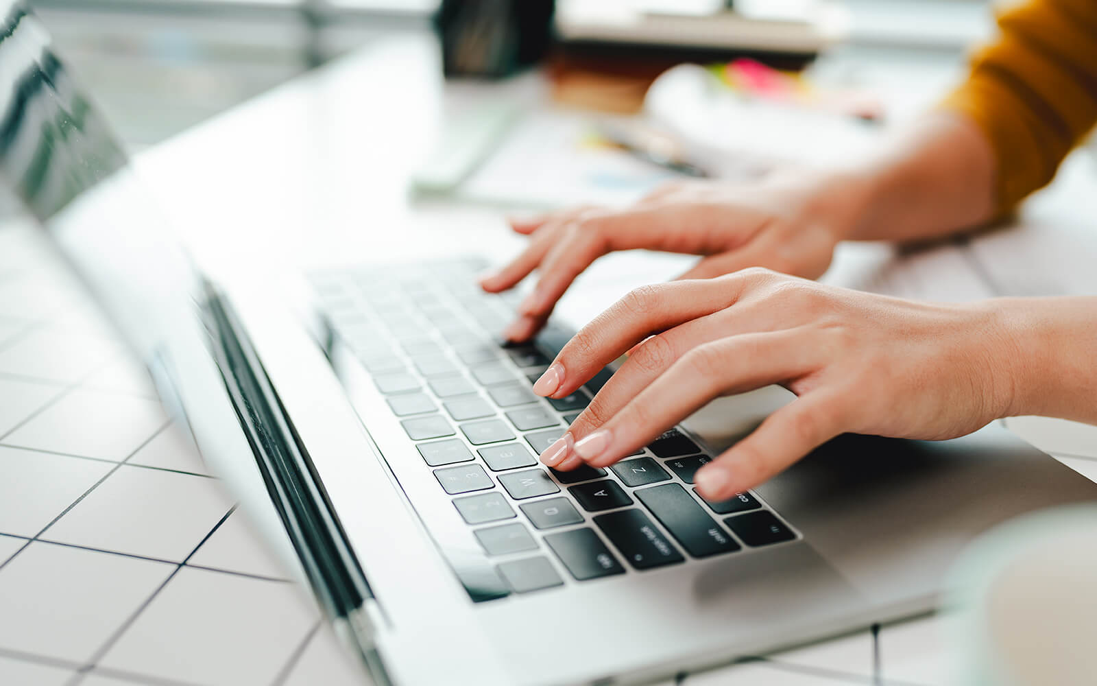 Hands typing on a laptop